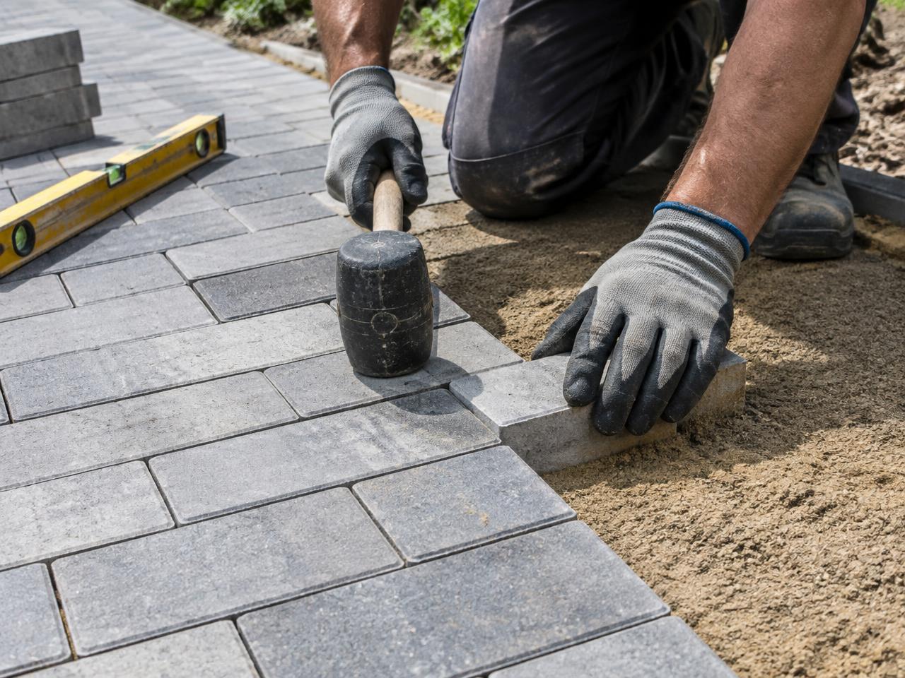 Worker laying paving stones into a walkway